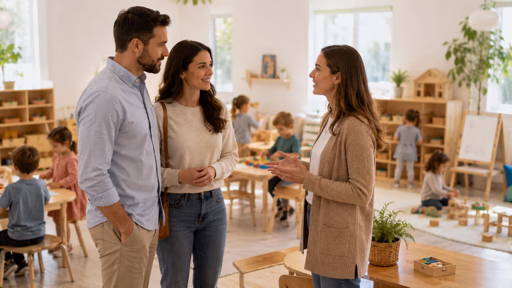 Parents touring preschool classroom and speaking with teacher