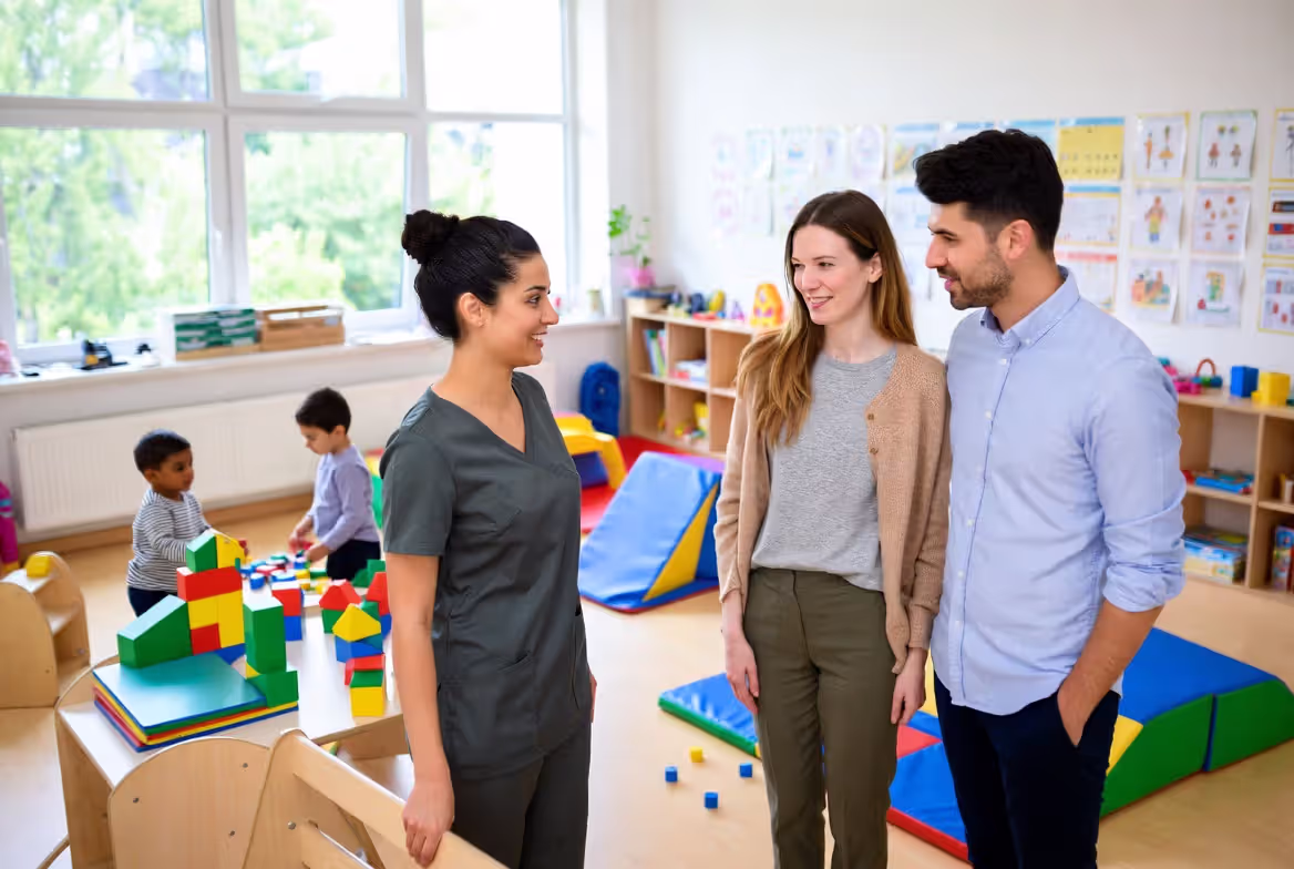 Parents touring nursery classroom with teacher explaining activities