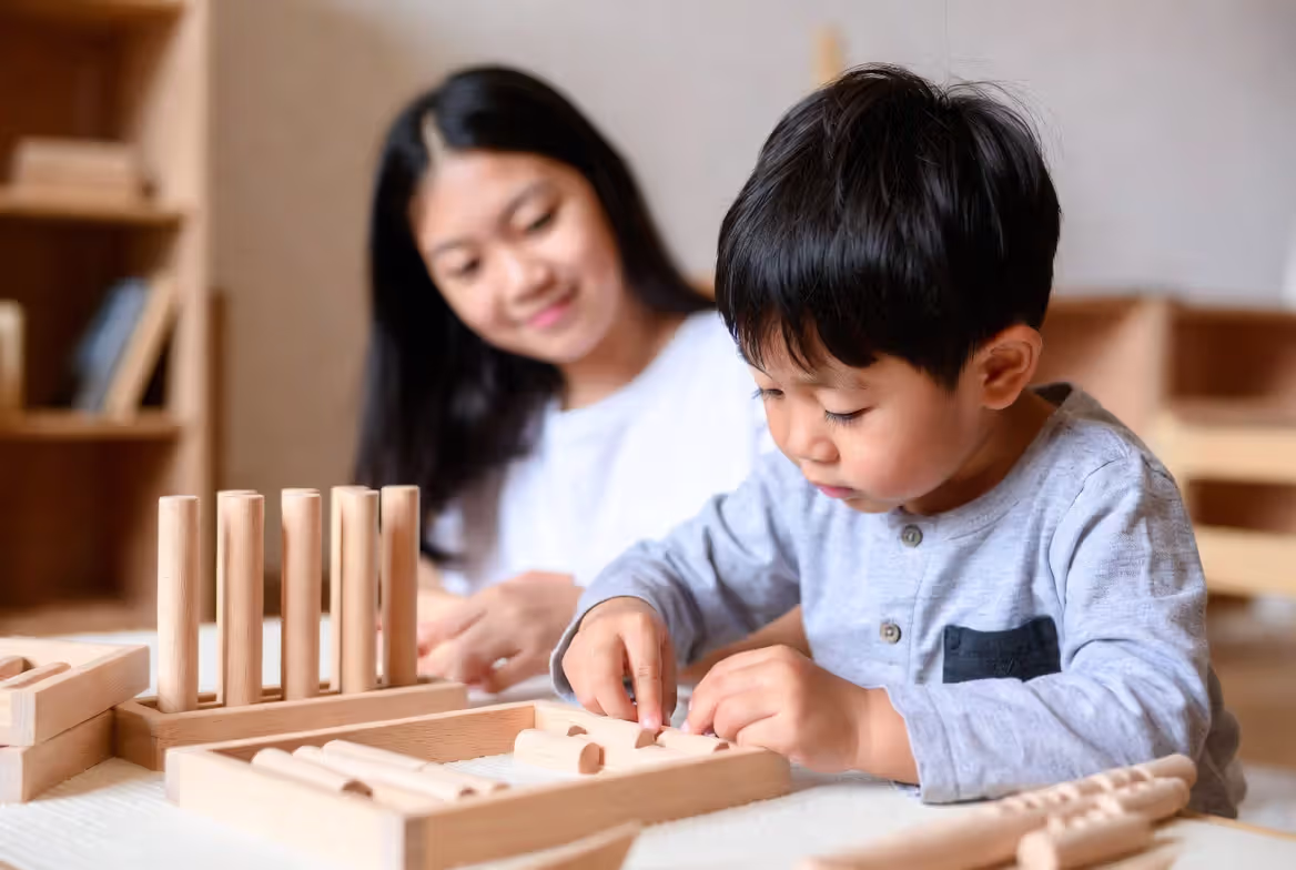 Young child learning independently in Montessori-style preschool classroom