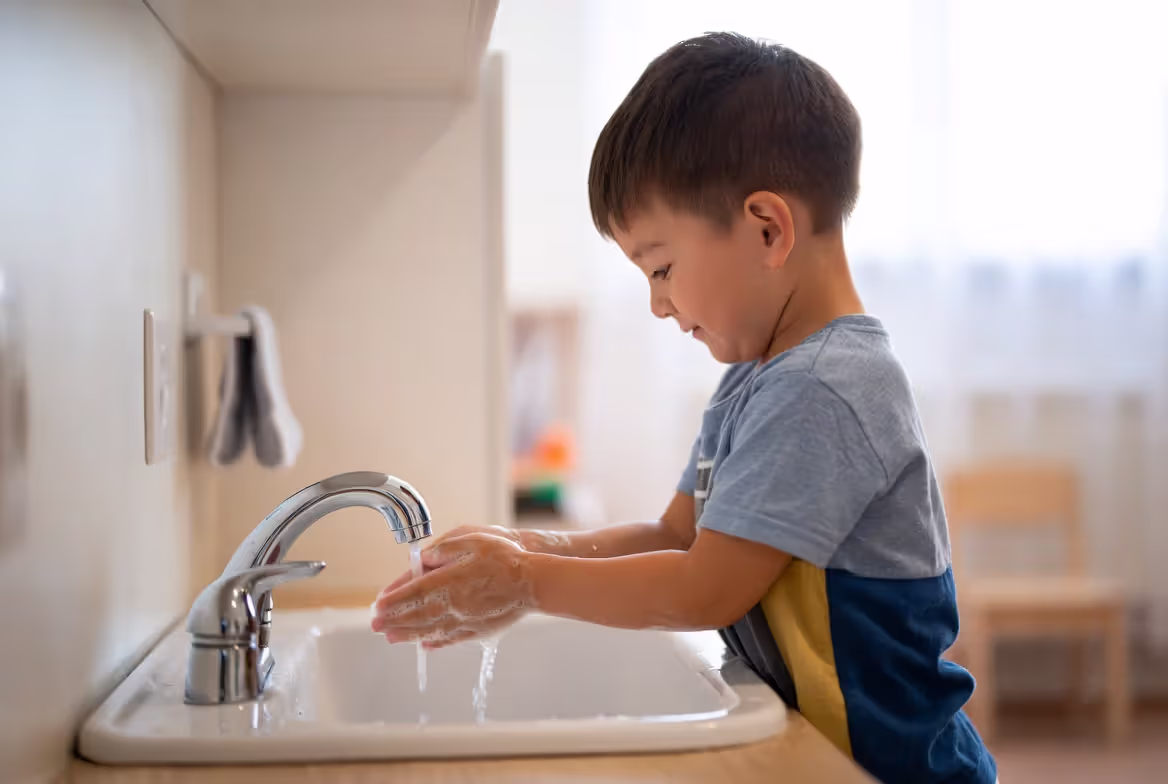 Young child practicing independent self-care skills before school