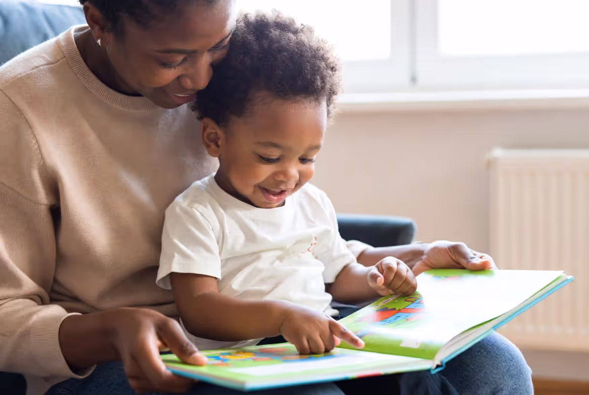 Parent supporting child with phonics reading practice at home