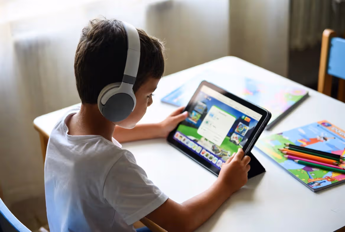 Elementary school child using reading app alongside traditional books